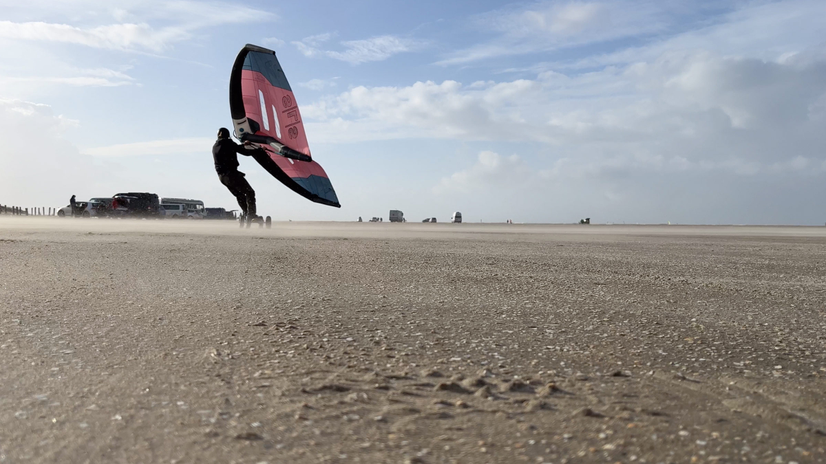 Der Wing beschleunigt das Board auf dem Strand